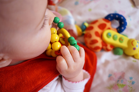 baby biting yellow and green toy thumbnail