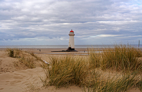 white lighthouse under cloudy sky thumbnail
