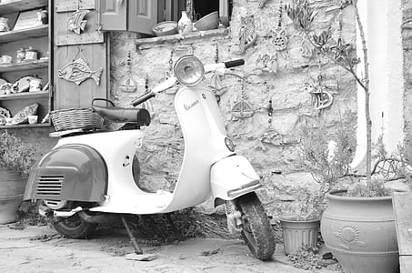 grayscale photo of motor scooter in front of wall thumbnail
