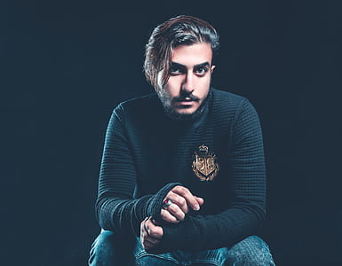Man Wearing Black Sweater Holding His Hand thumbnail