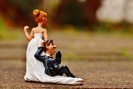selective focus photography of woman pulling man figurine thumbnail