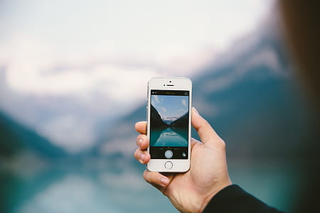 person holding turned on silver iPhone 5s thumbnail