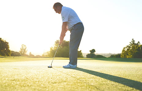 man playing golf in field thumbnail
