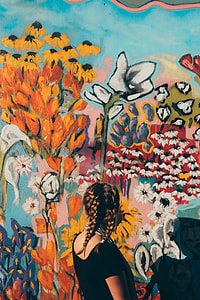 woman in black t-shirt looking at floral wall paintings during daytime thumbnail