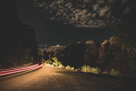 time-lapse photography of road surrounded by hills thumbnail