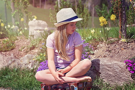 girl sitting by purple petaled flowers at garden thumbnail