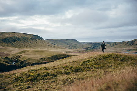 A hiker carrying a camera in rocky Iceland field thumbnail