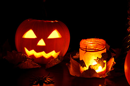 jack o lantern beside glass jar with candle thumbnail