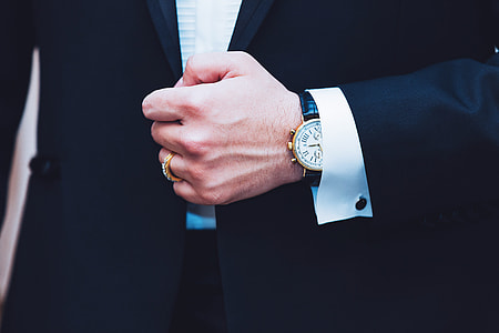Business man wearing a suit showing hand and watch thumbnail