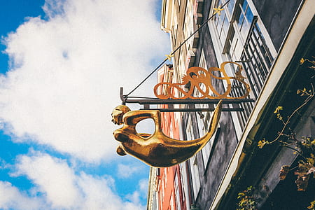 brass-colored Mermaid logo on wall thumbnail