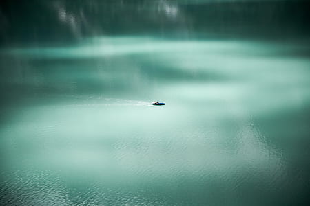 tilt shift photography of boat on body of water thumbnail