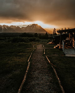 overlooking view of mountains under orange sky and dark clouds thumbnail