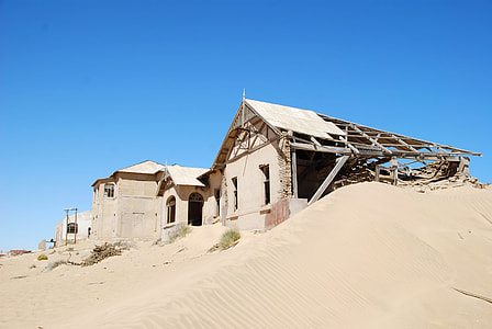 gray concrete house surround with brown sand at daytime thumbnail