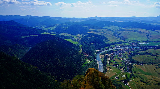 aerial photography of town beside river near mountain thumbnail