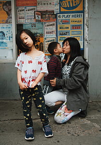 girl standing against boy kissing his mom thumbnail