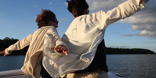 man and woman standing on top of boat thumbnail
