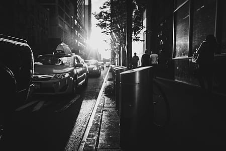 grayscale photo of people walking near parked cars and building thumbnail
