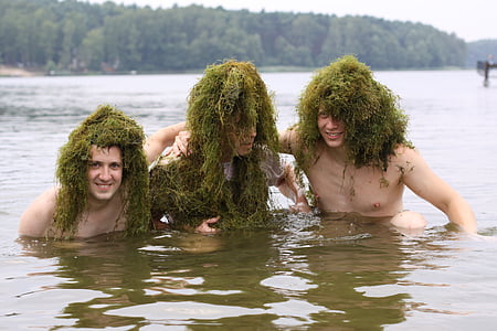 three person in body of water with green grasses on heads thumbnail