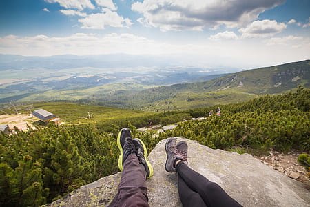 man and woman on top of hill under white clouds thumbnail