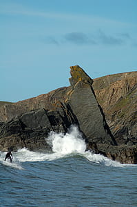 man surfing at beach during daytime photo thumbnail
