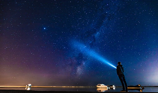 person using flashlight under the starry night thumbnail