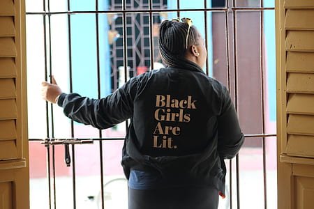 person standing in front of the gate white holding the bars thumbnail