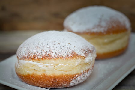 closeup photo of two baked bread with confectioner sugars on white ceramic dish thumbnail