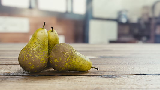 three green pears on brown table thumbnail