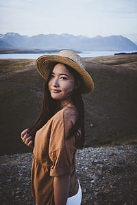 woman in brown elbow-sleeved top standing on sand thumbnail