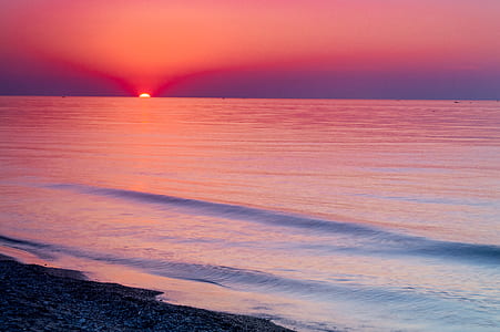 seashore during sunset with pink clouds thumbnail