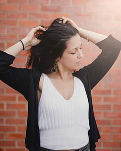 woman wearing white tank top touching her hair thumbnail