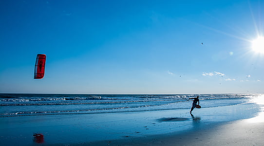 man holding canopy on seashore during day time thumbnail