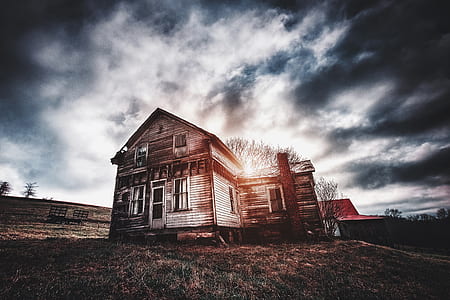 gray wooden house under cloudy sky thumbnail