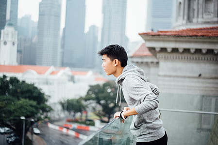 selective focus photo of man standing on balcony thumbnail