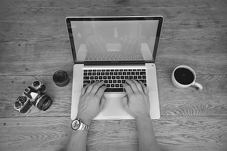 grayscale photo of person's hands typing on black and white laptop thumbnail