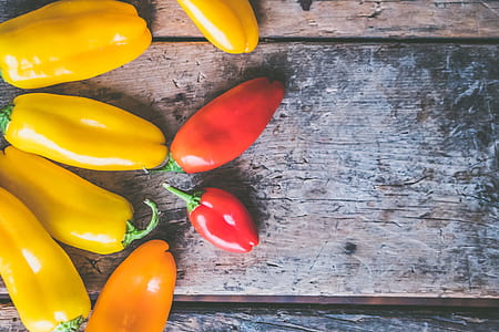 Yellow, Orange, and Red Peppers on Wooden Surface thumbnail