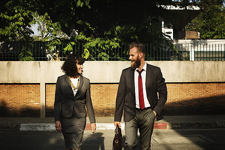 man wearing gray blazer and dress pants holding black bag standing near street thumbnail