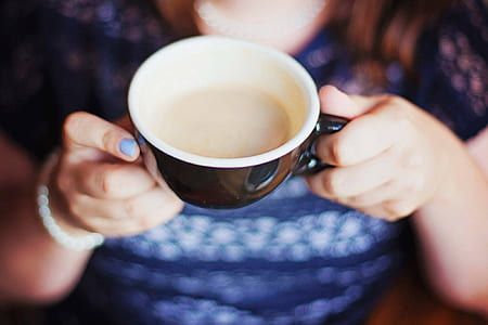 woman showing black and white ceramic cup thumbnail