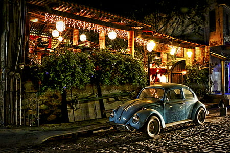blue Volkswagen Beetle coupe parked beside the store thumbnail
