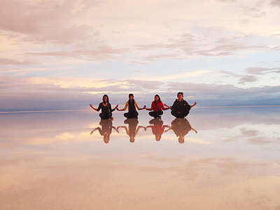 four women sitting at white field under cloudy sky during daytime thumbnail