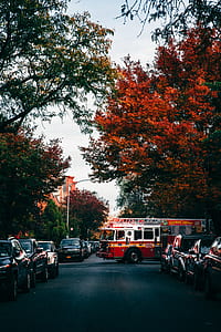 red and white firetruck on road filled with parked vehicles thumbnail