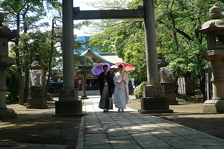 man and woman under gray concrete arc holding umbrellas thumbnail