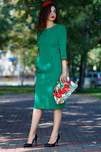 woman wearing long-sleeved dress carrying floral purse thumbnail