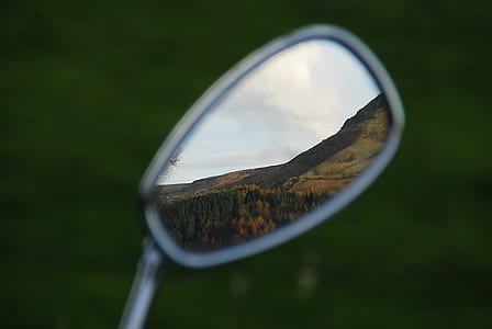 motorcycle side mirror showing grass fields thumbnail