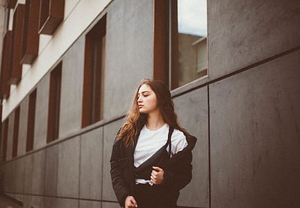 woman standing near building wall during daytime thumbnail