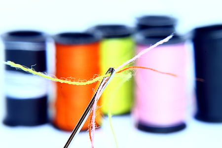 tilt shift photo of thread with needle thumbnail