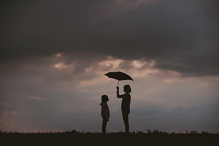 silhouette of two toddlers under the umbrella thumbnail