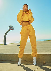 woman holding her yellow hoodie standing on road thumbnail