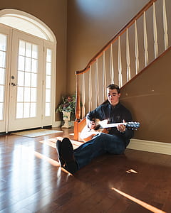 man playing brown acoustic guitar thumbnail