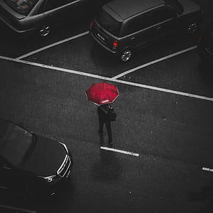 woman standing on street holding umbrella thumbnail